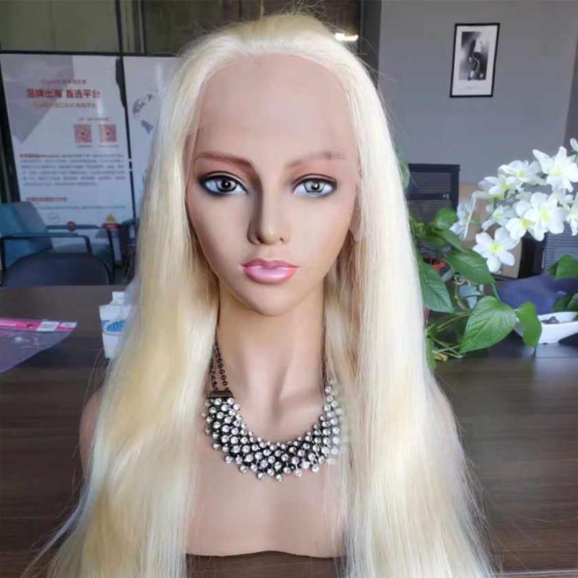 A mannequin wearing a necklace and a long blonde wig.