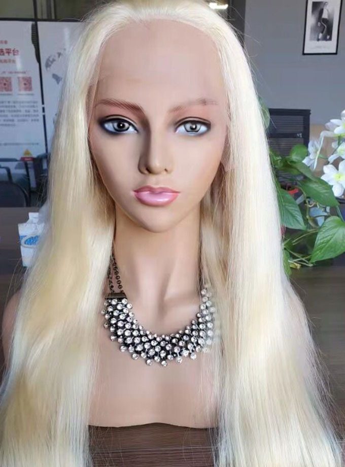 A mannequin wearing a necklace and a long blonde wig.